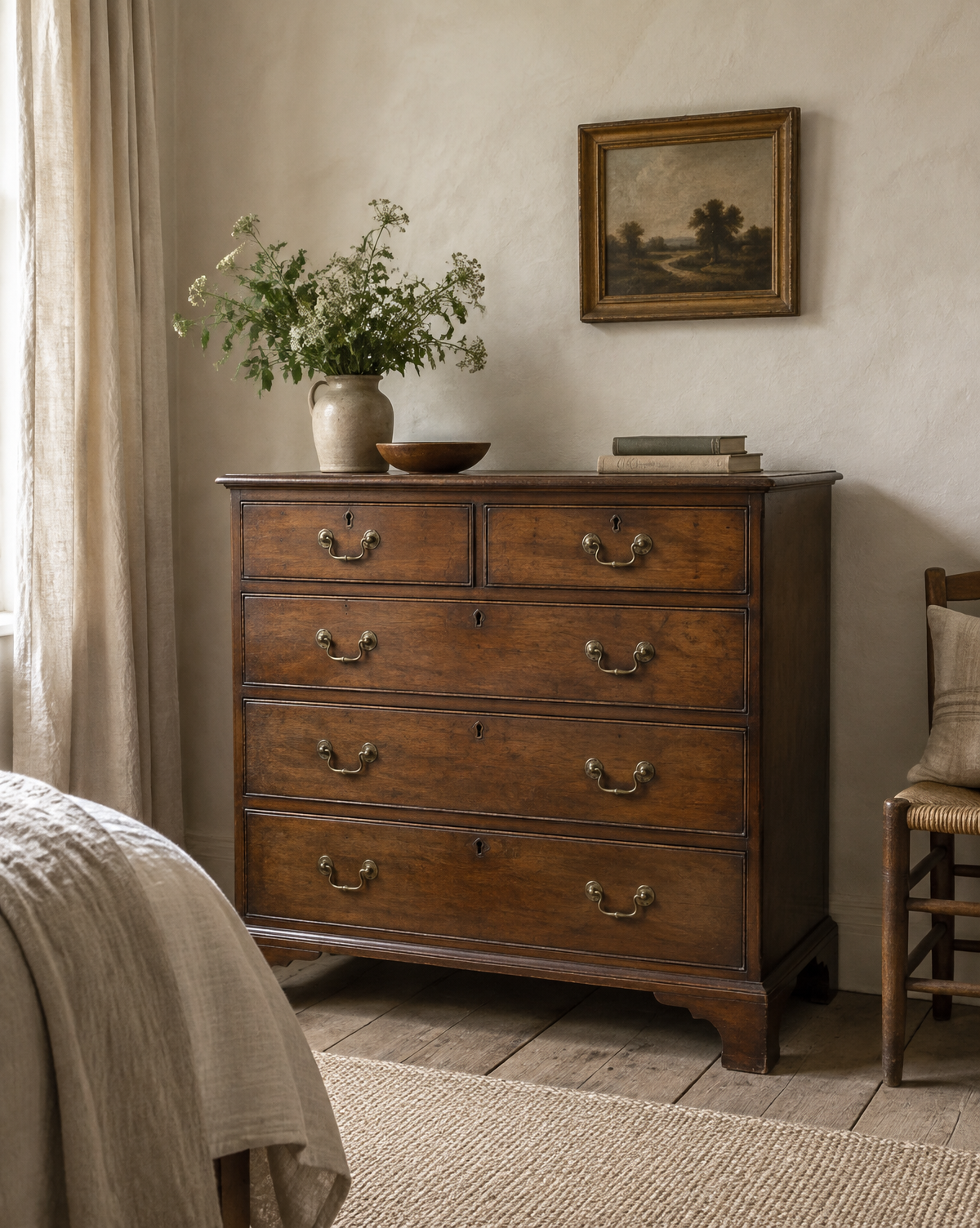 Georgian oak chest of drawers beside a plain bedroom wall